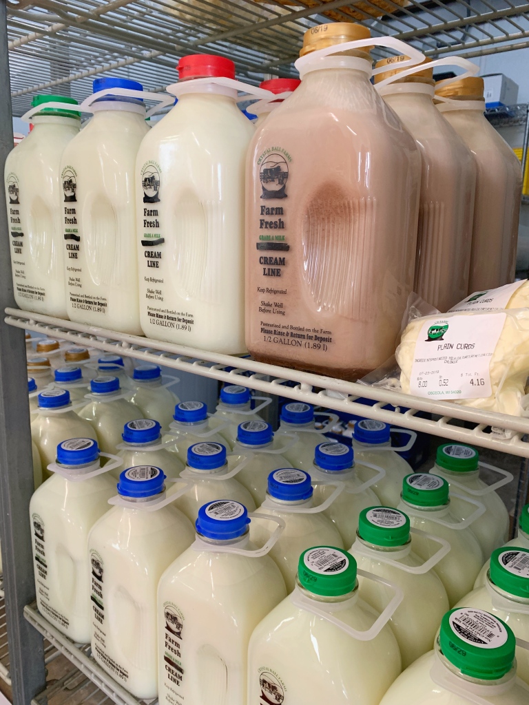 Stocked shelfs of various milk jugs